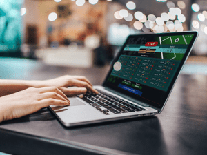 Player gambling online on laptop with sports betting site